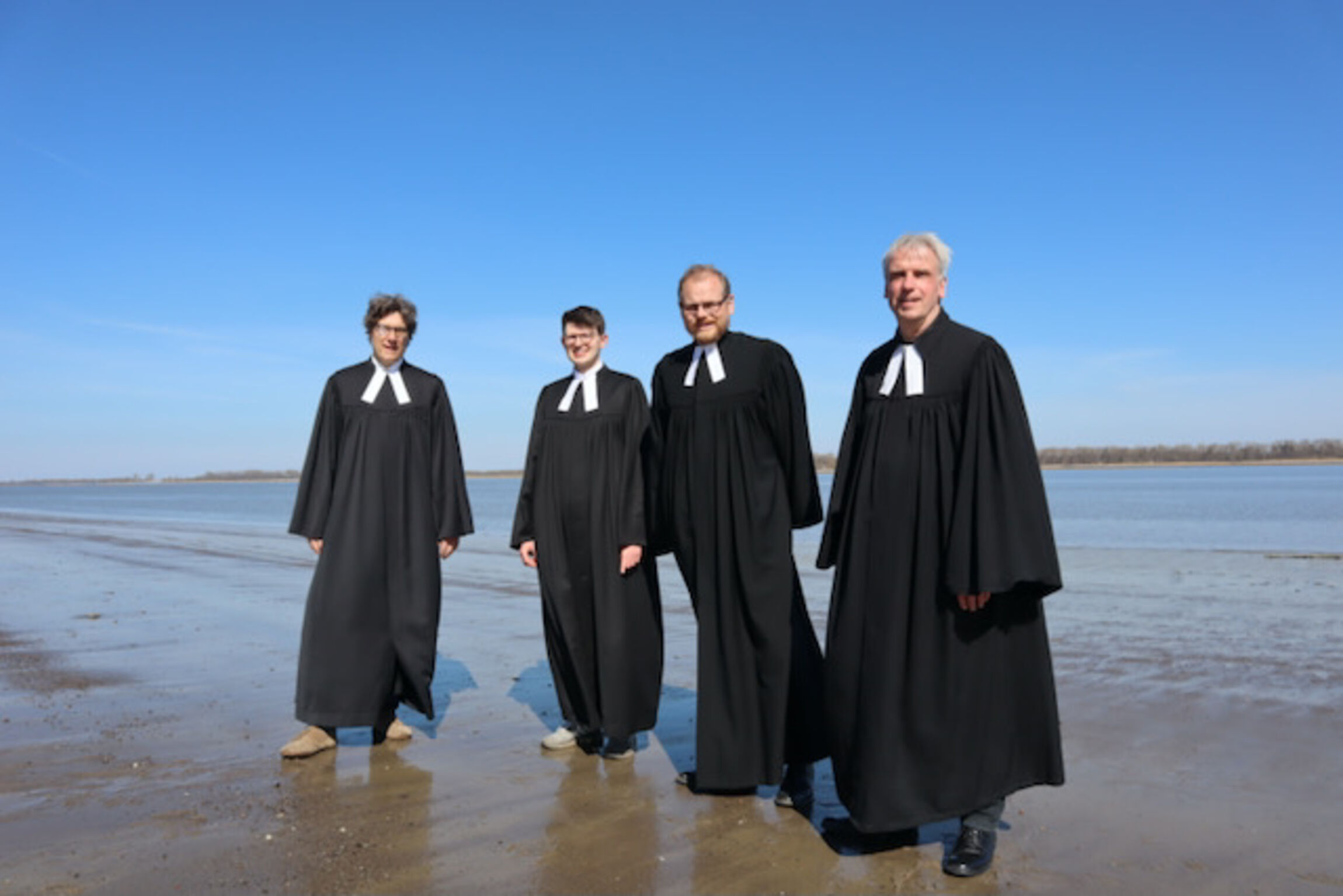 Foto von links nach rechts: Die Pastoren Christian Kurzewitz, Tobias Grotefend, Jan Wutkewicz und Wilfried Behr am Elbstrand in Abbenfleth