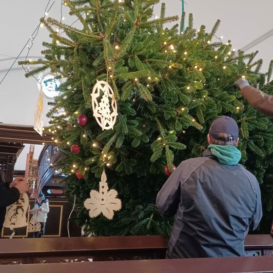 Der Schmuck für die Baumspitze wird angebracht, bevor der Baum aufgerichtet wird.